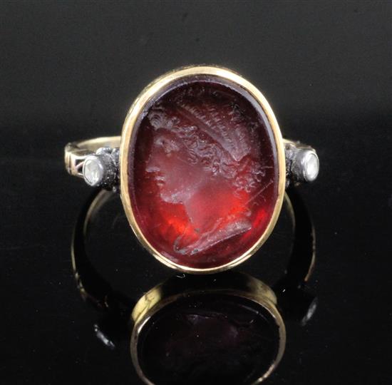 A Georgian yellow metal and oval red intaglio foil backed? ring with old cut diamond set shoulders, size L.